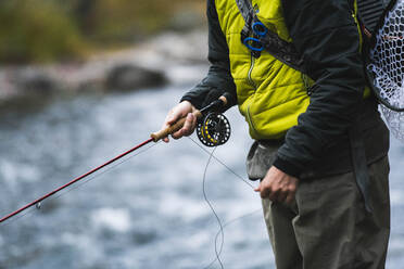 Mittelteil eines Mannes beim Fliegenfischen am Roaring Fork River - CAVF90789