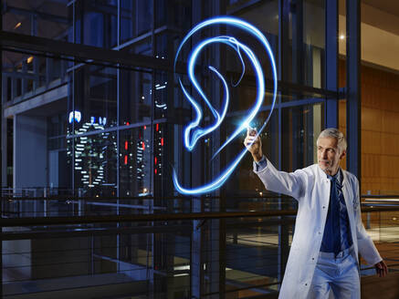 Male otolaryngologist examining ear in laboratory at hospital - RORF02472