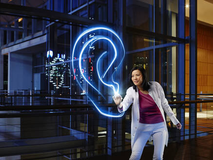 Female otolaryngologist examining ear with light painting in laboratory at hospital - RORF02498