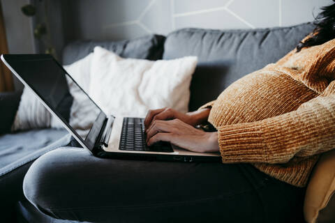 Pregnant woman using laptop at home stock photo