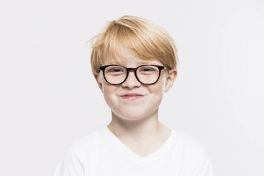 Lächelnder Junge mit Brille vor weißem Hintergrund - SDAHF01003