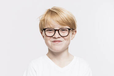 Smiling boy in eyeglasses against white background - SDAHF01003