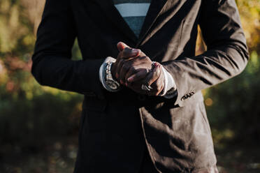 Young man with hands clasped standing in park - EBBF01674