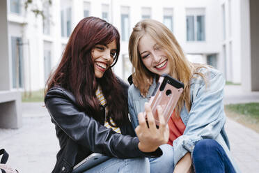 Fröhliche junge Universitätsstudentinnen machen ein Selfie auf dem Campus - TCEF01360