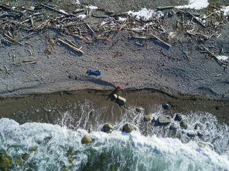 Drohnenaufnahme eines Wanderers am Meeresufer im Winter - CAVF90833