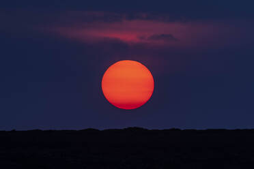 Idyllische Aufnahme von orangefarbenen Mond über Silhouette Landschaft - CAVF90835