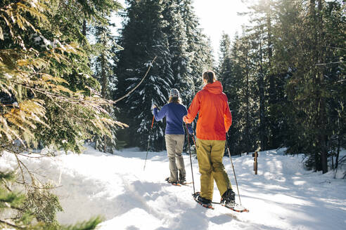 Zwei junge Frauen gehen an einem sonnigen Tag auf dem Mt. Hood Schneeschuhlaufen. - CAVF90844