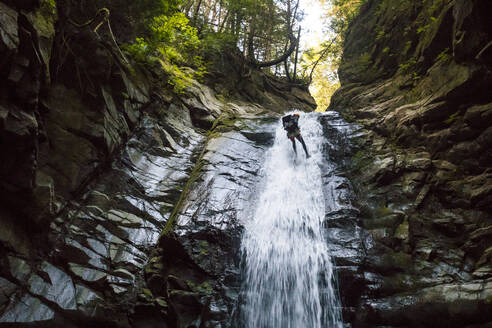 Abseilen eines Forschers in einem Wasserfall aus geringer Höhe - CAVF90865