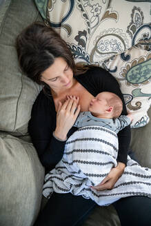 Neugeborenes Baby schläft friedlich an der Brust der Mutter. - CAVF90894