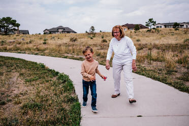 Grandma and grandson playing outside on a cloudy day - CAVF90936