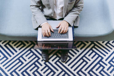 Businessman using laptop in hotel - DGOF01769