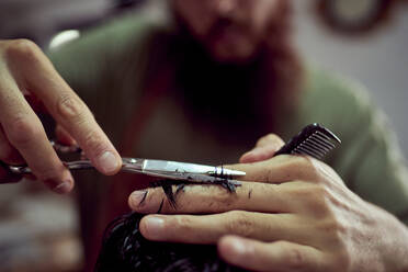 Detailzeichnung eines Friseurs, der mit einer Schere Haare schneidet - CAVF91011