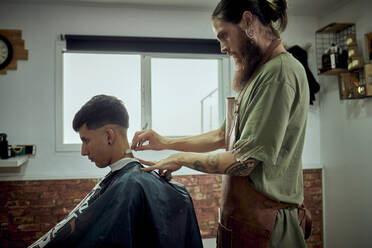 Ein Friseur arbeitet mit einem Messer an einem Kunden - CAVF91012