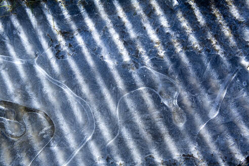 Eis, Konturen von gefrorenem Wasser, Schatten und Sonnenlicht. - MINF15335