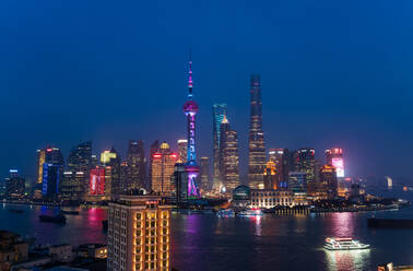 Skyline des Finanzdistrikts Pudong über den Huangpu-Fluss in der Abenddämmerung, Shanghai, China. - MINF15403