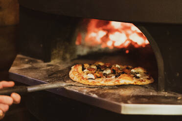 Nahaufnahme einer Pizza in einem Holzofen in einem Restaurant. - MINF15446