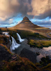 Spectacular scenery of mountain top and waterfall under cloudy sunset sky in Iceland - ADSF17752