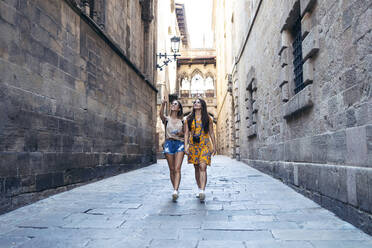 Friends talking while exploring Gothic Quarter at Barcelona, Catalonia, Spain - JSRF01186