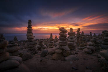 Picturesque view of high stone towers near sea under colorful cloudy sky at sundown in Canary Islands - ADSF17887