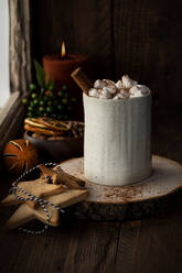 Aromatic cacao with marshmallow and cinnamon stick served on wooden table with cookies in star shape prepared for Christmas celebration - ADSF18049