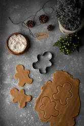 Draufsicht auf die Anordnung von rohem Teig für Lebkuchen und Ausstechformen auf dem Tisch, der für die Zubereitung des Desserts für die Weihnachtsfeier vorbereitet wurde - ADSF18051