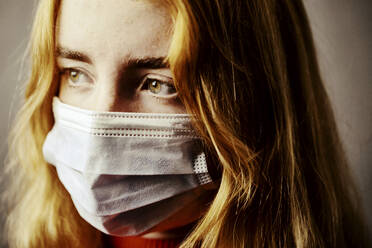 Close-up of teenage girl wearing protective face mask - JATF01283