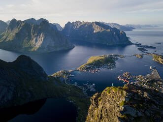 Eine Forscherin steht auf einem Berg bei Reine, Lofoten, Norwegen - MALF00172