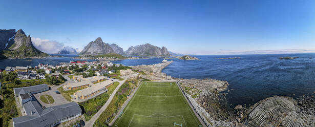 Fußballplatz am Meer vor blauem Himmel bei Reine, Lofoten, Norwegen - MALF00176