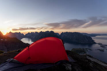 Tent on mountain peak against sky during sunset at Reinebringen. Lofoten, Norway - MALF00191