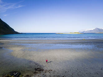 Frau steht am Strand von Fredvang, Lofoten, Norwegen - MALF00209
