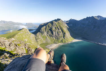 Mann mit Sportschuhen auf einem Berg in Ryten, Lofoten, Norwegen - MALF00219