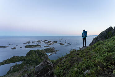 Wanderin bewundert den Sonnenuntergang auf dem Festvagtinden, Lofoten, Norwegen - MALF00269