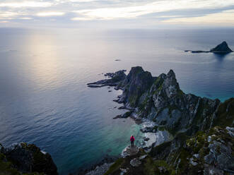 Frau bewundert die Aussicht, während sie auf einem Berg in Matind, Andoya, Norwegen steht - MALF00281