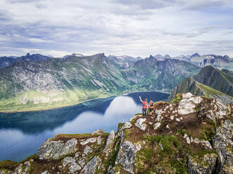 Männlicher Forscher mit Blick auf die Aussicht, während er auf dem Berg Husfjellet, Senja, Norwegen steht - MALF00293