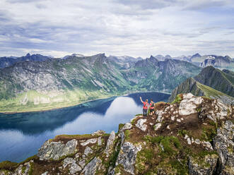 Male explorer looking at view while standing on mountain at Husfjellet, Senja, Norway - MALF00293