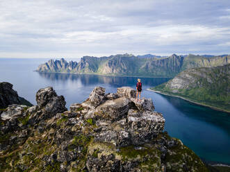 Female hiker looking at view standing on mountain at Husfjellet, Senja, Norway - MALF00297