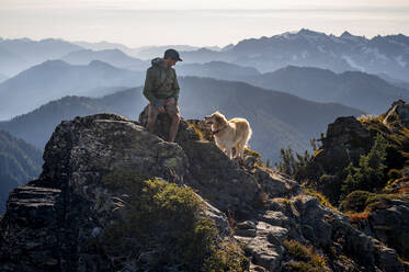 Männlicher Wanderer und Hund in den Kaskaden mit rauchiger Aussicht - CAVF91089