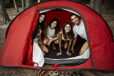 Lächelnde Familie bei der Freizeitgestaltung im Zelt während der Ferien - RCPF00318