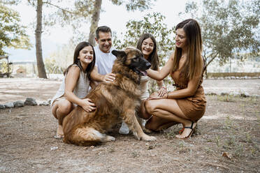 Lächelnde Familie mit Hund im Park - RCPF00320