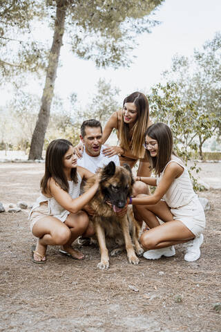 Cheerful parents and children with dog in park stock photo