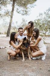 Cheerful parents and children with dog in park - RCPF00328