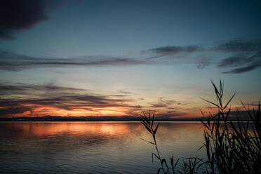 Malerischer Blick auf den See vor einem dramatischen Himmel bei Sonnenuntergang - RCPF00377