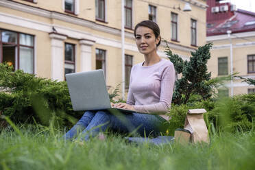 Unternehmerin mit Laptop im Park sitzend - VPIF03273