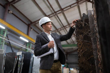 Focused male manager exploring marble slabs - CAVF91138