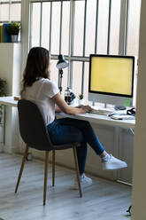 Businesswoman working on computer while sitting at office - GIOF09818