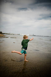 Sechsjähriger Junge, der in der Bucht von Coronado über Felsen springt - CAVF91162