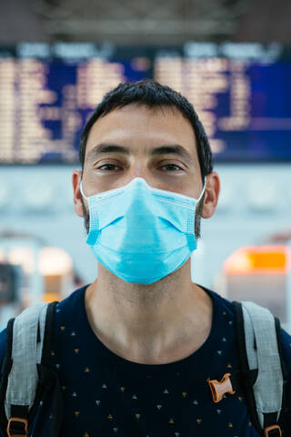 Portrait of a young man wearing a face mask on the airport stock photo