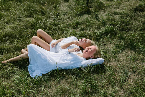 Lachende Dorfkinder im Gras liegend - CAVF91222