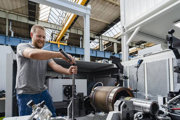 Manual worker smiling while working at factory - DIGF13426