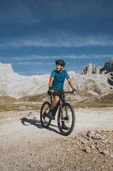 Radfahrer mit Fahrrad bei der Erkundung des Nationalparks Picos de Europa an einem sonnigen Tag, Kantabrien, Spanien - DMGF00352